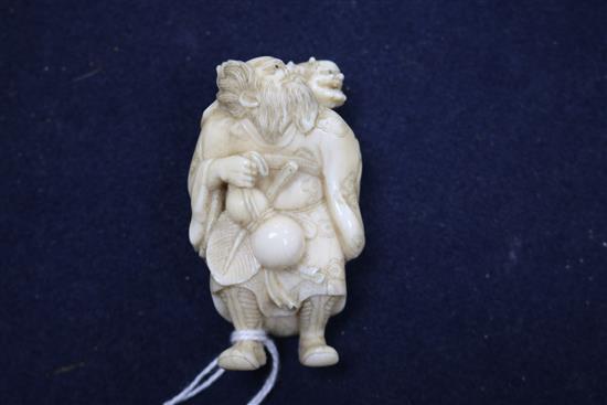 A 19th century carved ivory okimono figure, Shoki and an oni, signed